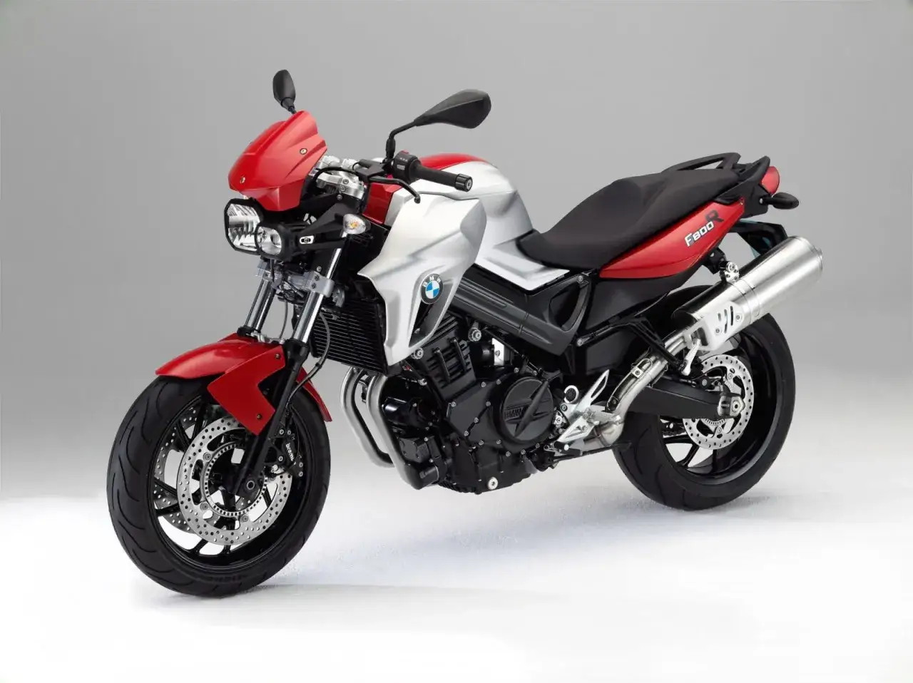 Czerwono-srebrny motocykl BMW F800R, gotowy do jazdy. Poznaj jego bmw f800r dane techniczne i poczuj moc!