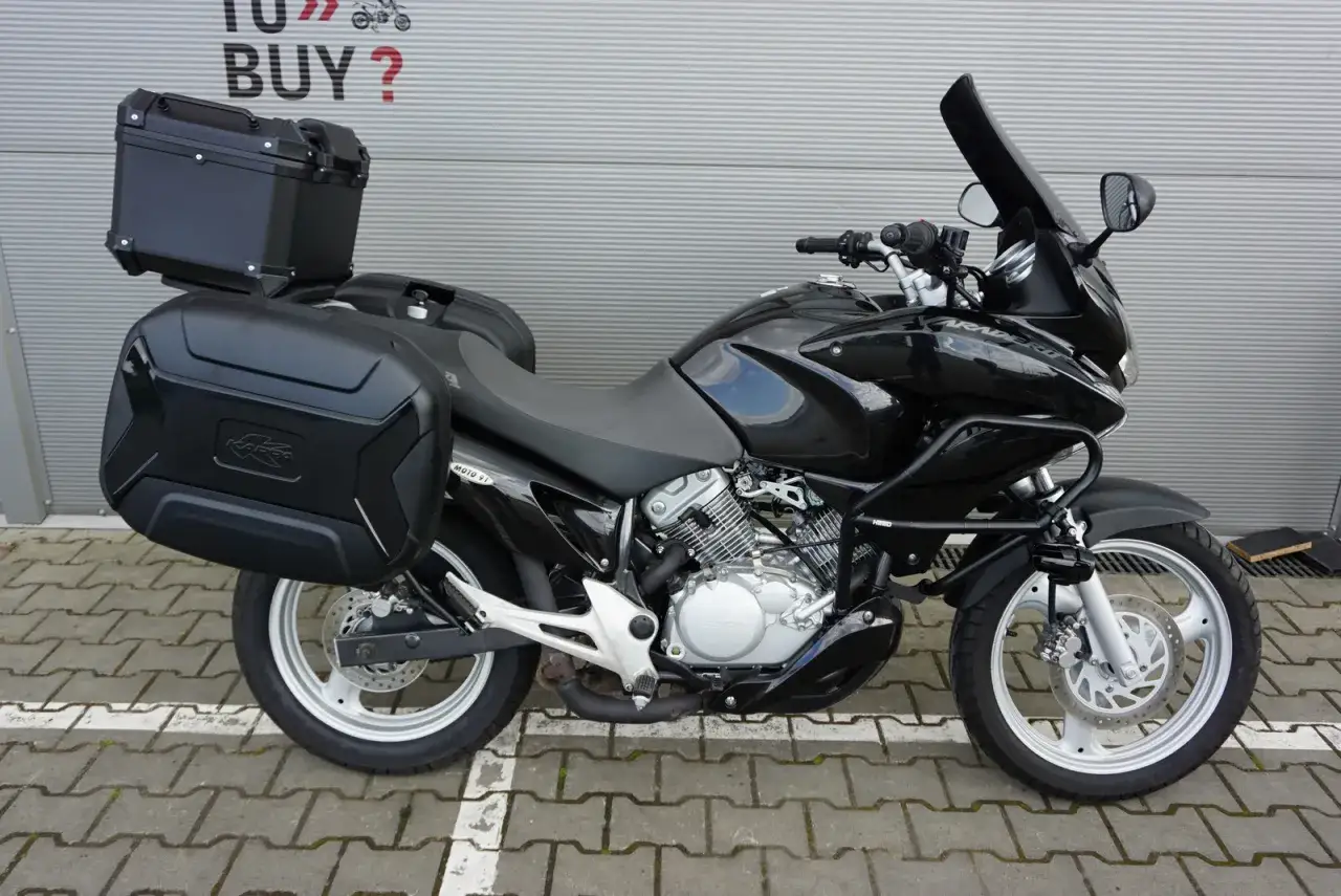 Czarny motocykl Honda Varadero 125 z kuframi, gotowy na odblokowanie mocy i dalekie podróże.