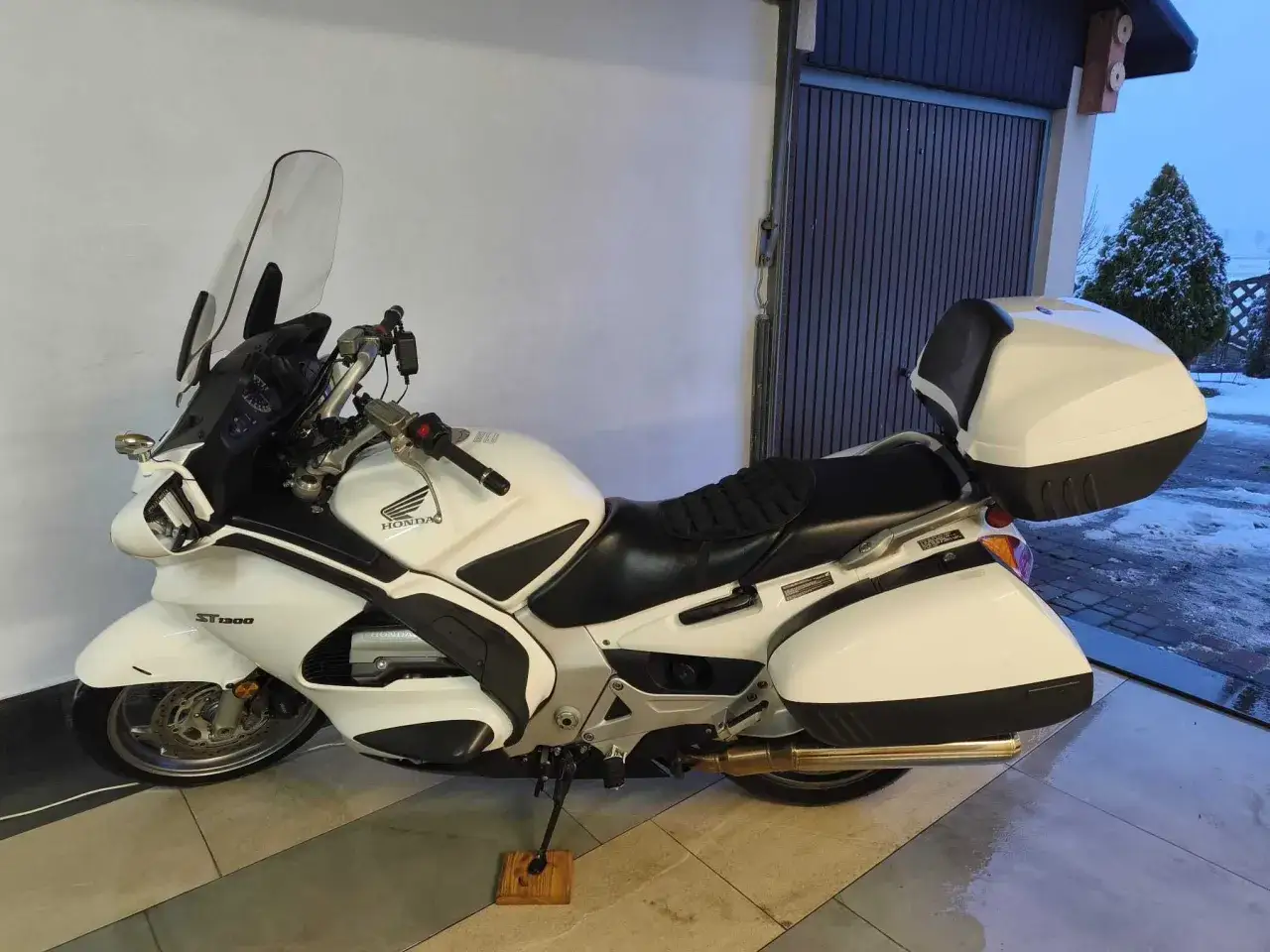 Biały motocykl Honda Pan European ST1300 z kuframi, gotowy na dalekie podróże.