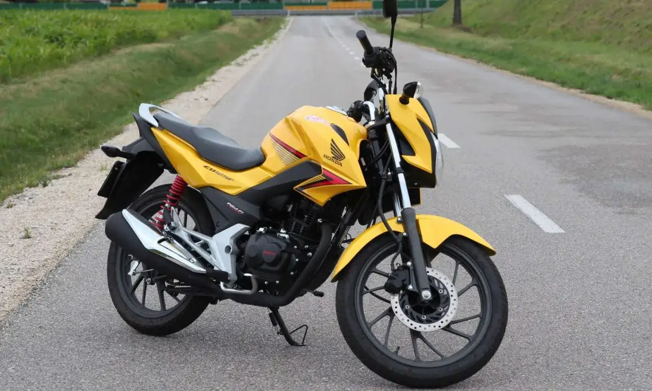 Żółty motocykl Honda CBF 125 na drodze. Sprawdź honda cbf 125 dane techniczne, by poznać jego możliwości.