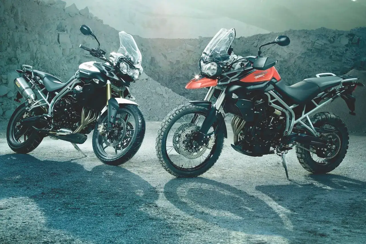 Dwa motocykle Triumph Tiger 800 XC, jeden biały, drugi pomarańczowy, gotowe na przygodę. Dane techniczne kuszą.