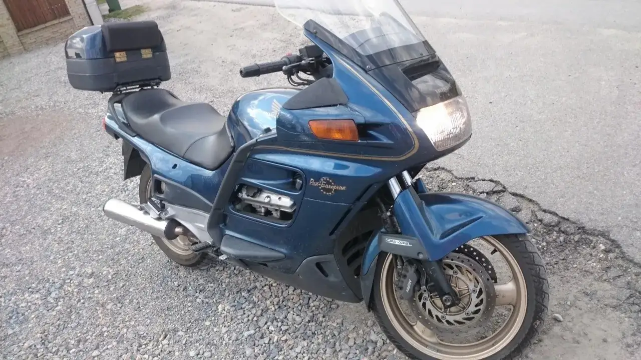 Granatowy motocykl Honda Pan European z kufrem na bagaż, gotowy na długie trasy.