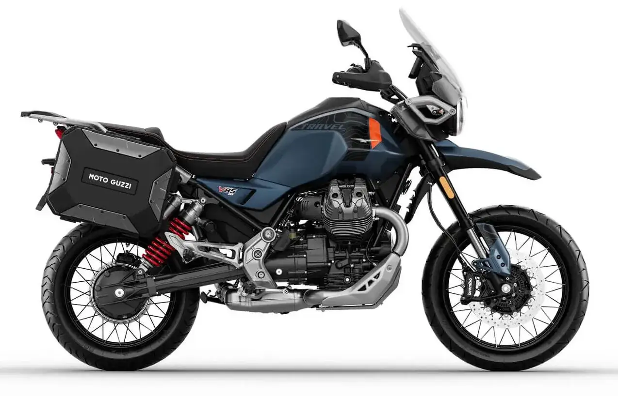 Niebieski motocykl Moto Guzzi V85 TT z kuframi, gotowy na przygodę.