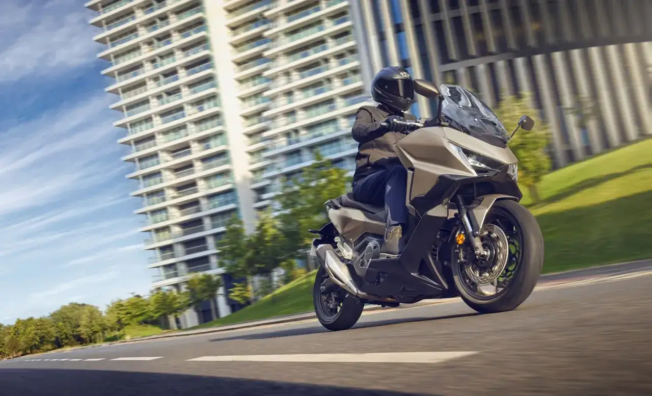 Motocyklista na Honda Forza 750 pędzi ulicą. Czy osiągnie swoją honda forza 750 prędkość maksymalna?