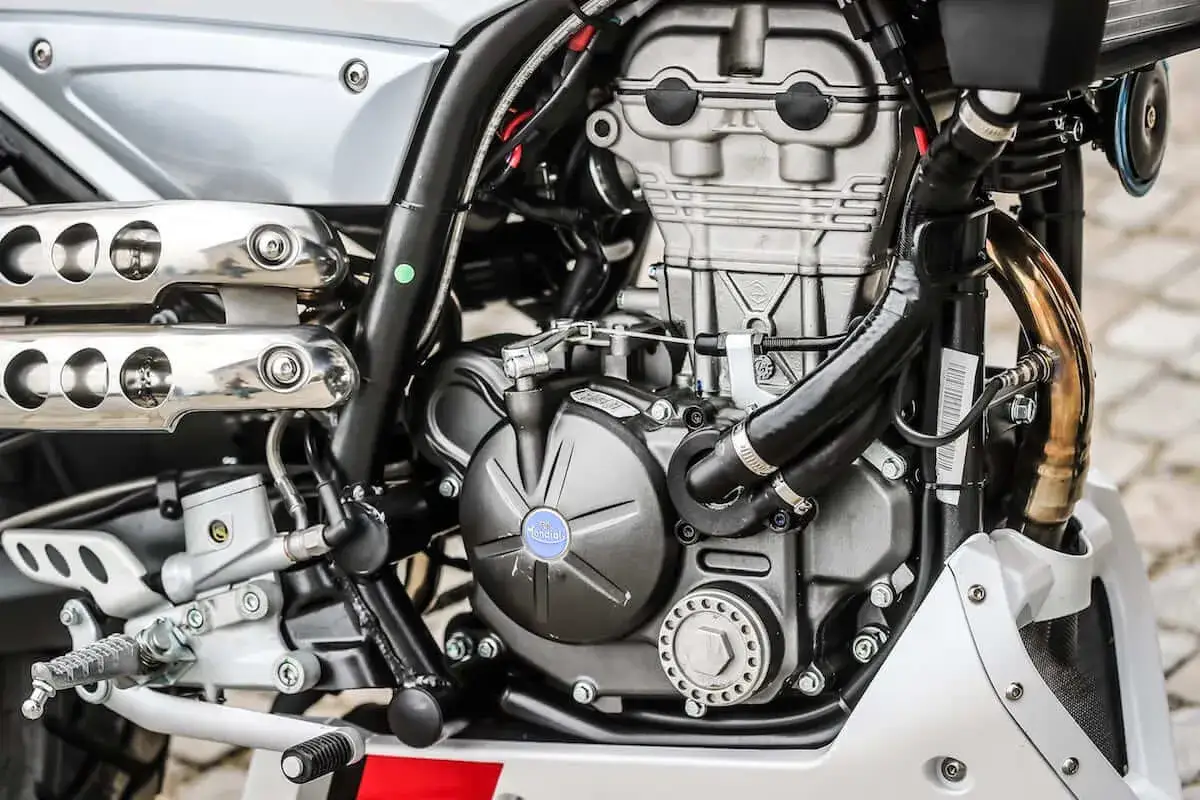 Silnik motocykla Mondial. Rozrusznik kręci, a motocykl nie odpala. Widoczne elementy układu wydechowego i chłodzenia.