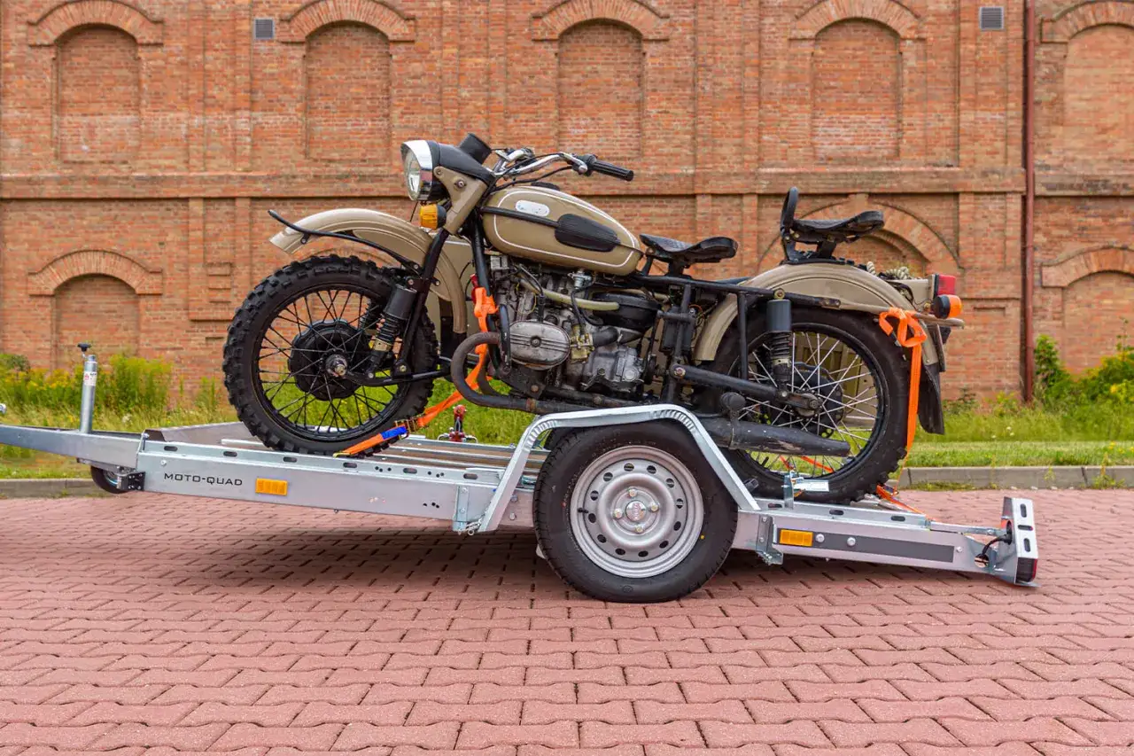 Jak przewieźć motocykl na zwykłej przyczepie? Zobacz, jak solidnie zamocować pojazd za pomocą pasów transportowych na przyczepie MOTO-QUAD.