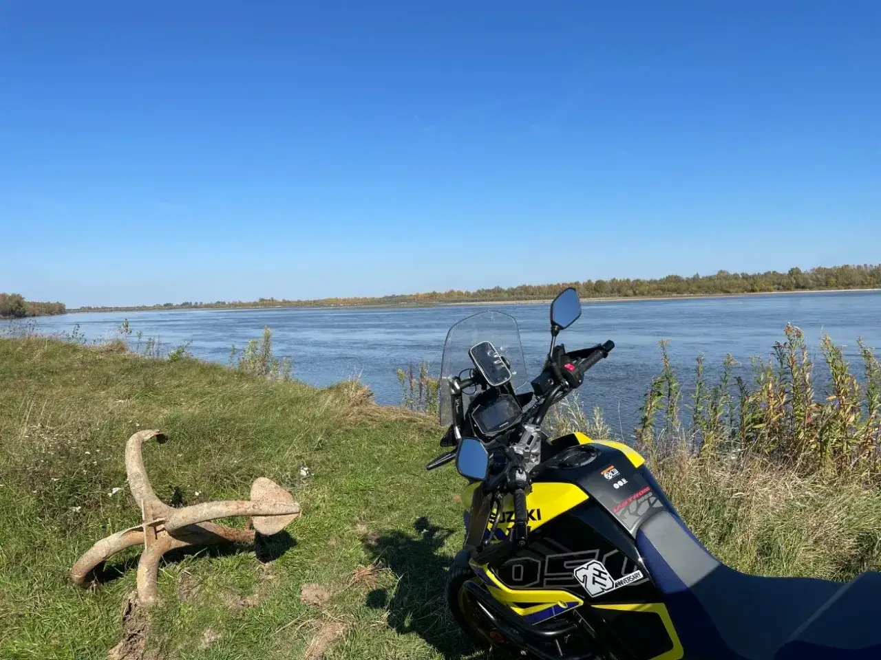 Motocykl Suzuki czeka na dalszą podr&oacute;ż po malowniczych trasach motocyklowych mazowieckich, nad szeroką rzeką.