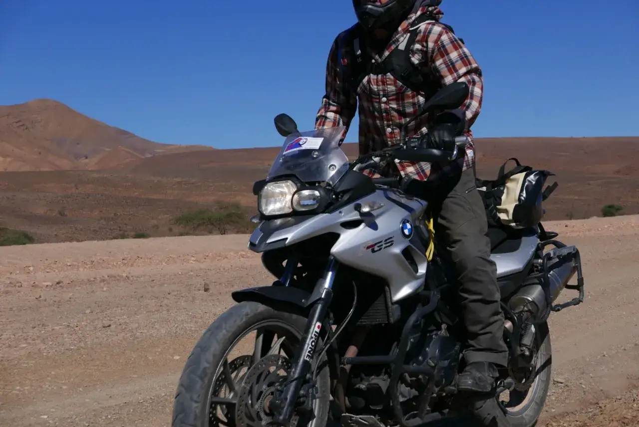 Motocyklista na BMW F 650 GS w pustynnym krajobrazie. Poznaj dane techniczne tego wszechstronnego motocykla.