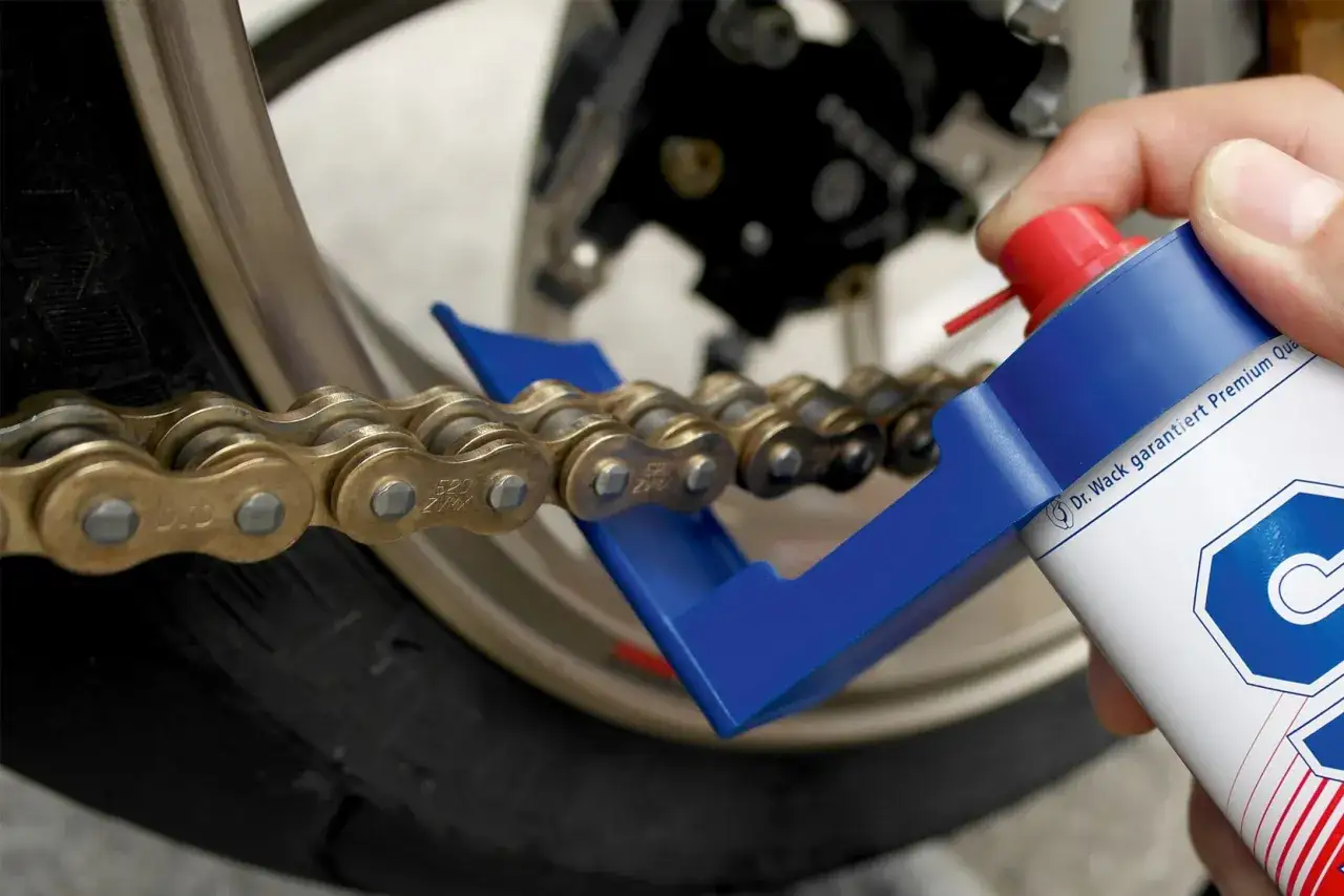 Czyszczenie łańcucha motocyklowego. Użycie specjalnego aplikatora i preparatu do smarowania, by zapobiec objawom luźnego łańcucha.