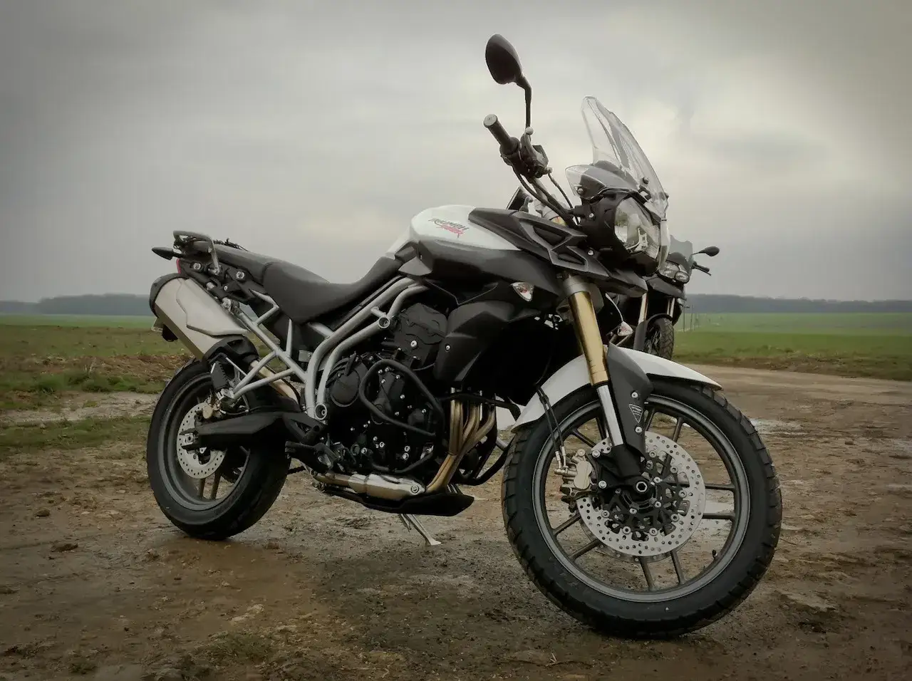 Triumph Tiger 800 dane techniczne: motocykl adventure na błotnistej drodze, gotowy na każdą wyprawę.