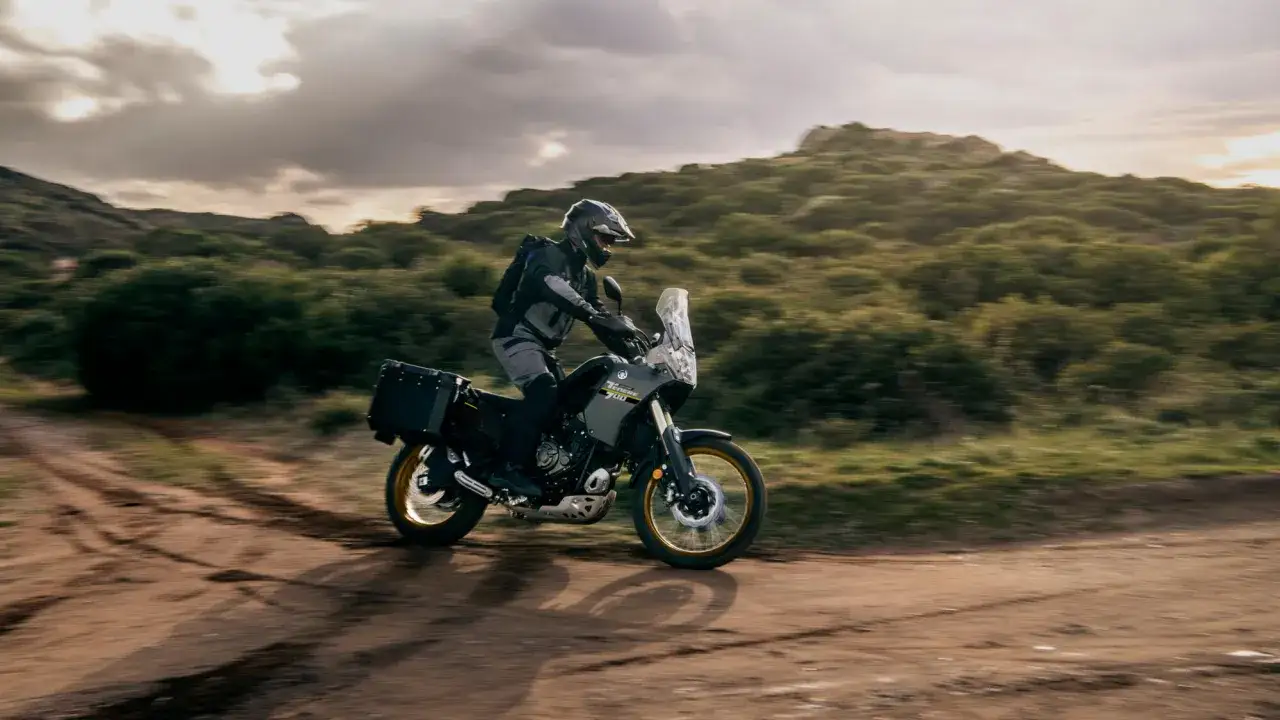 Motocyklista na Yamaha Tenere 700 z kuframi przemierza pustynny teren. Sprawdź yamaha tenere 700 dane techniczne.