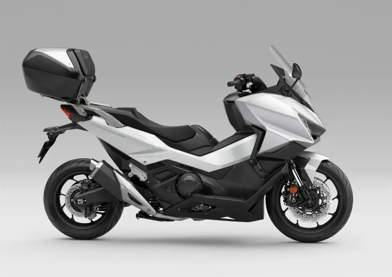 Srebrny skuter Honda Forza 750 z kuferkiem, gotowy na osiągnięcie swojej prędkości maksymalnej.