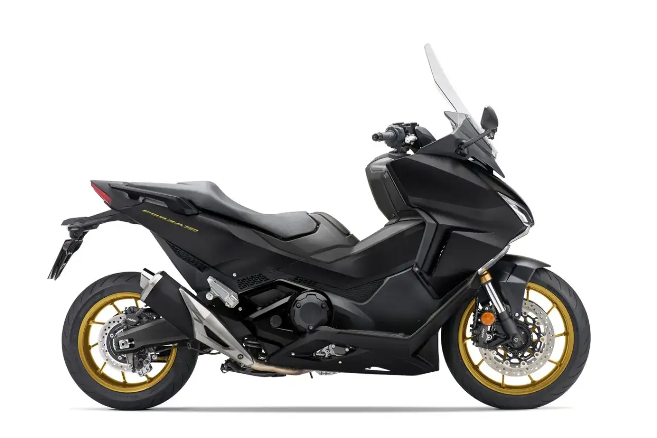 Czarny skuter Honda Forza 750 z matowym wykończeniem i złotymi felgami. Zaprojektowany z myślą o osiąganiu wysokiej prędkości maksymalnej.