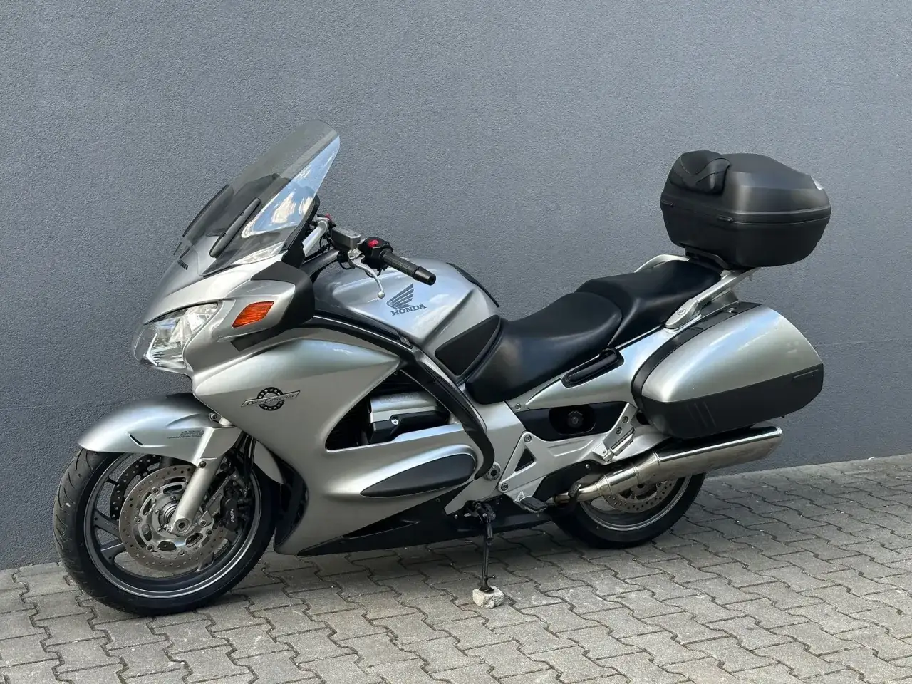 Srebrny motocykl Honda Pan European z kuframi, gotowy na długie podróże.