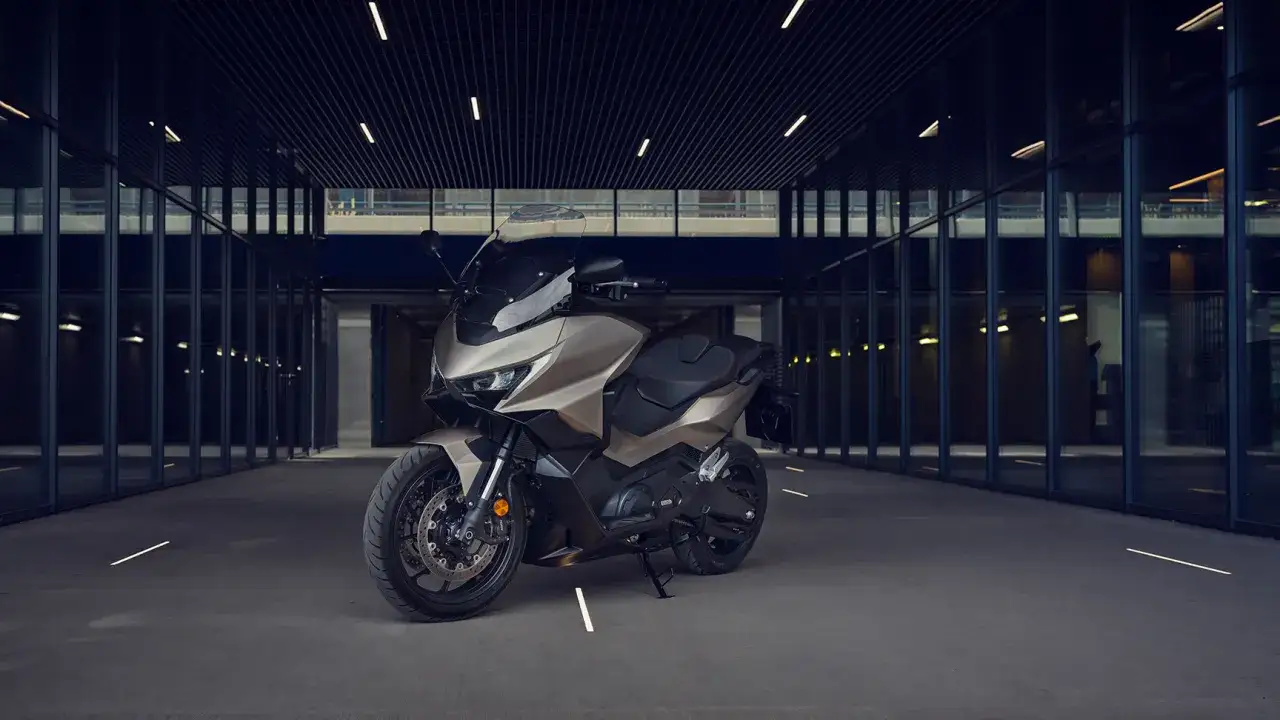 Elegancki, brązowy skuter Honda Forza 750, gotowy do osiągnięcia swojej prędkości maksymalnej.
