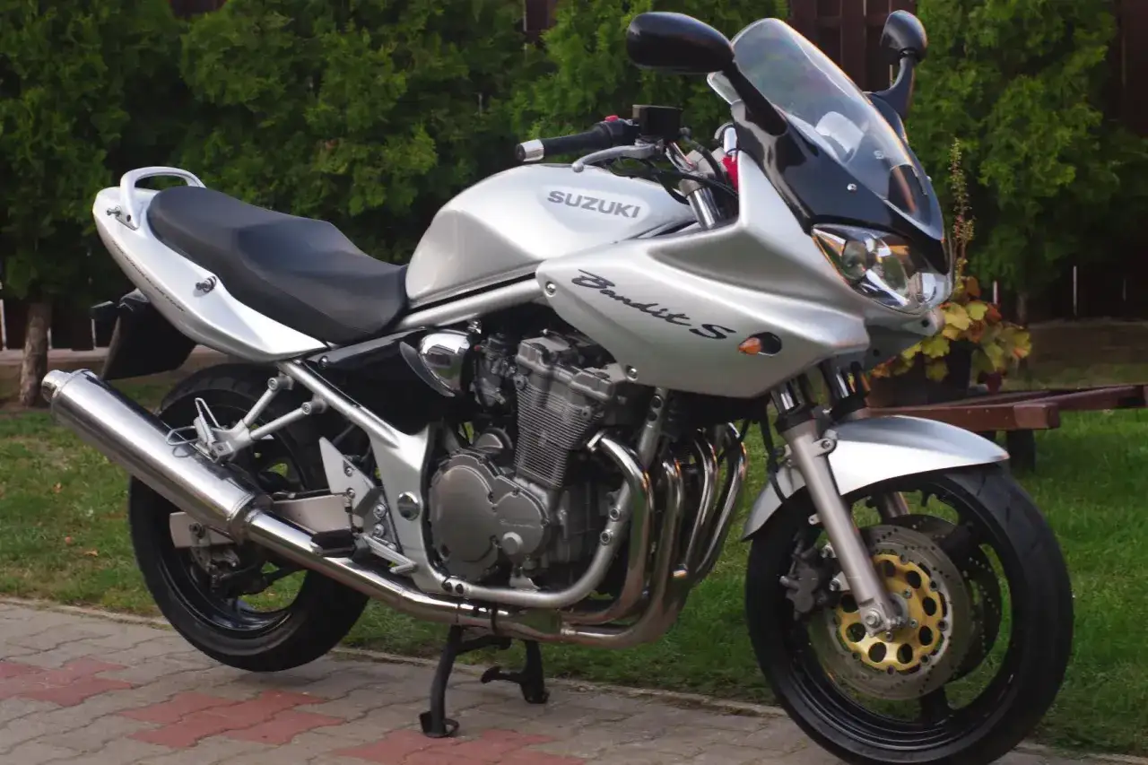 Srebrny Suzuki Bandit 600, gotowy do jazdy, z widocznym silnikiem i wydechem. Jego moc czeka na odkrycie.