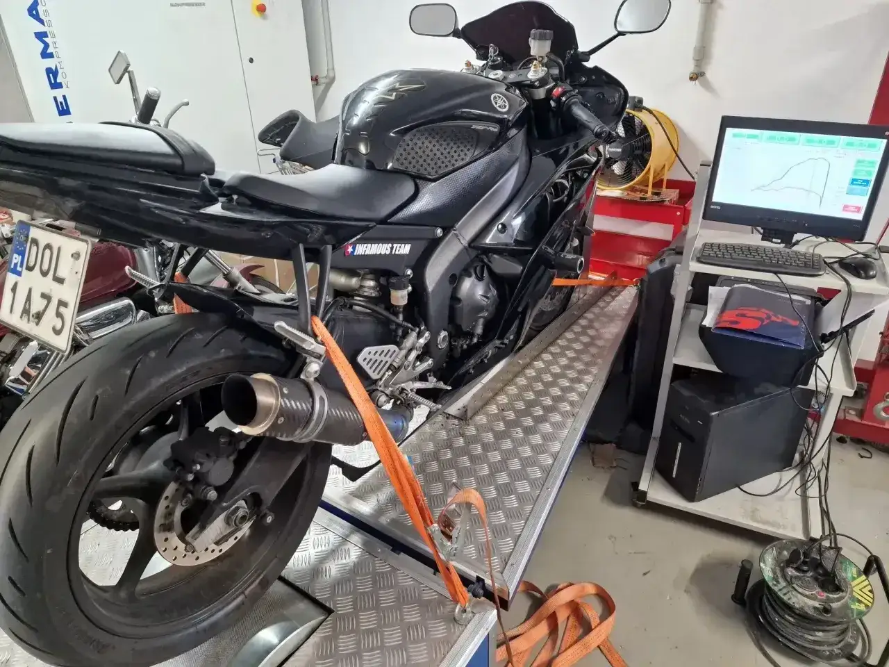 Czarny motocykl Yamaha na hamowni, przygotowany do testów. Pomiar mocy, blokowanie motocykla na A2.