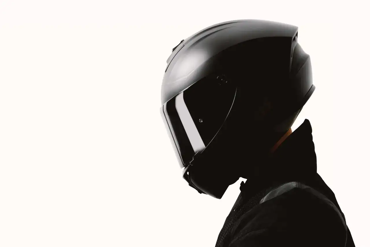 Czarny kask motocyklowy z przyciemnianą szybką, pokazujący różne rozmiary kasków motocyklowych.