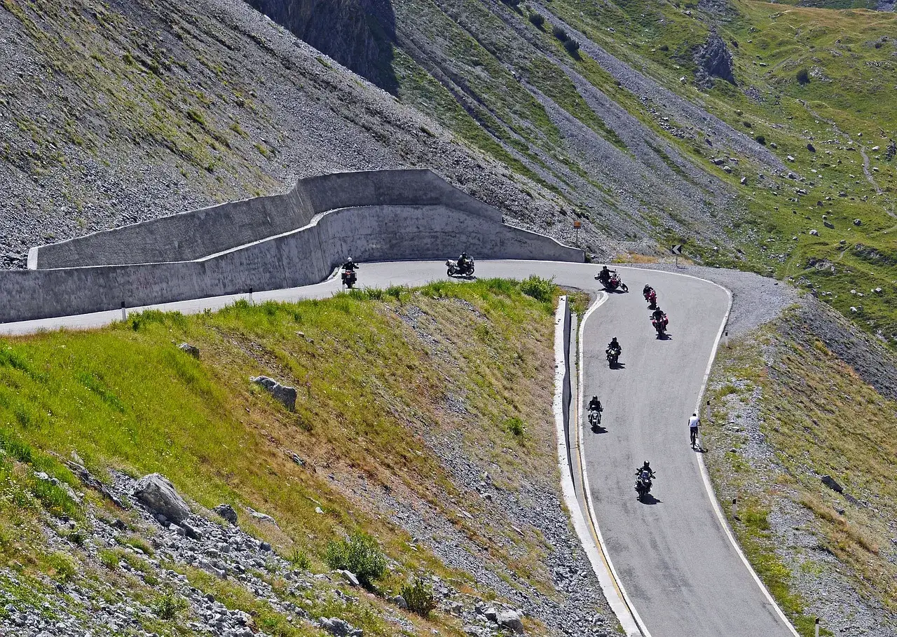 Motocykliści pokonują zakręty najbardziej krętej drogi w Polsce, pnącej się po zboczu góry.