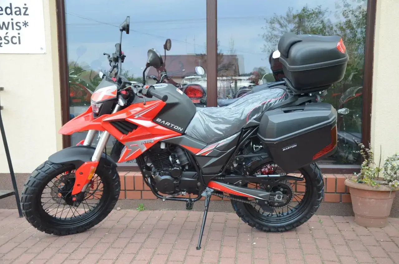 Czerwony motocykl Barton Hyper 125 z kuframi, gotowy na zwiększenie mocy i przygodę.