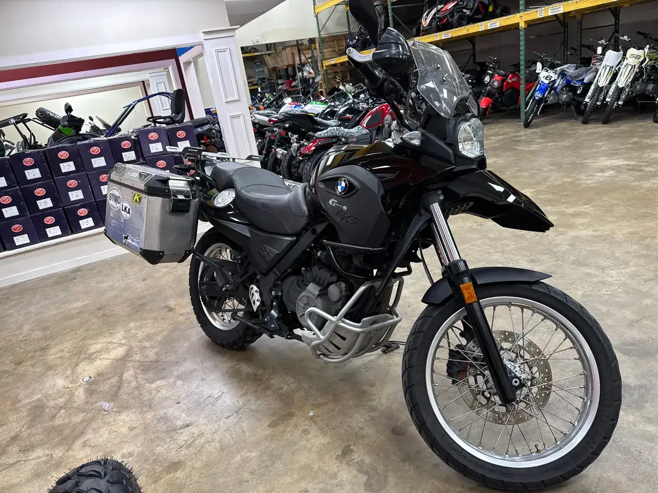 Czarny motocykl BMW F 650 GS z kuframi bocznymi, gotowy na przygodę. Dane techniczne tego modelu są imponujące.