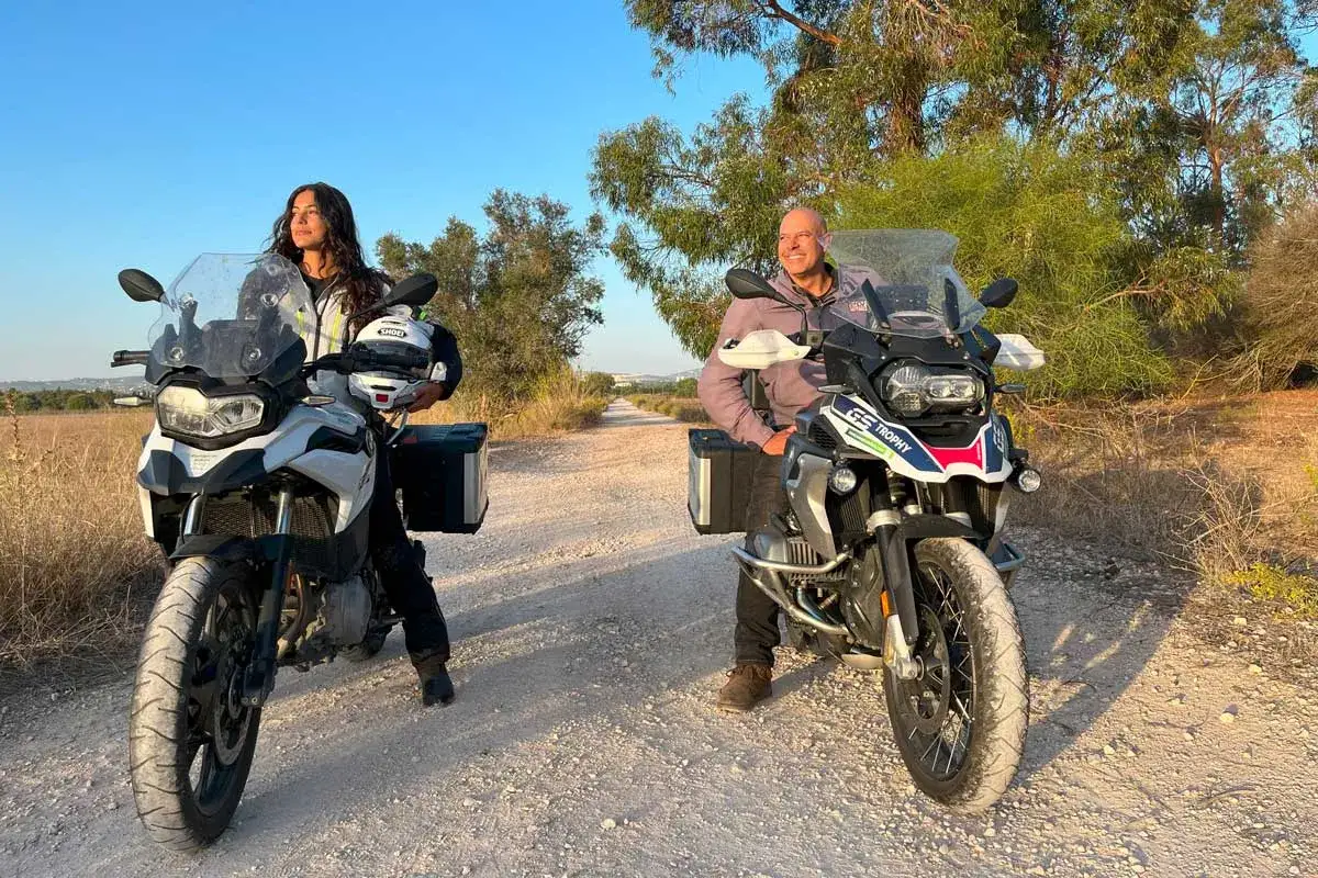 Para na motocyklach 500 cm3, gotowa na przygodę na piaszczystej drodze wśród drzew.