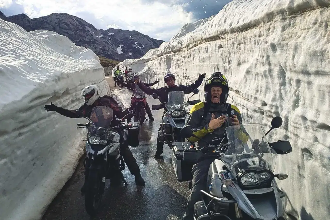 Ekscytująca podróż motocyklem po Europie przez zaspy śnieżne. Uśmiechnięci motocykliści cieszą się przygodą.
