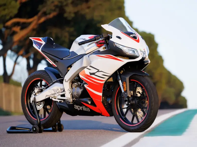Sportowy motocykl Aprilia RS 125 2T, biało-czerwony, z widocznymi detalami i napisem "RS". Idealny do poznania jego aprilia rs 125 2t dane techniczne.