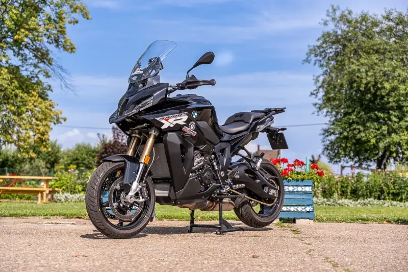 Czarny motocykl BMW S1000 XR na postoju, gotowy do podróży. Poznaj jego bmw 1000 xr dane techniczne i ruszaj w drogę!